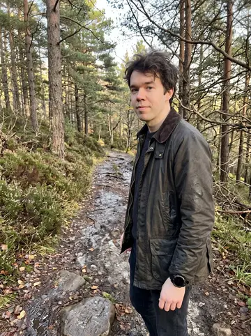 Sjoerd, AI character: a forest path above Glen Affric near Inverness, damp heather and pine trees behind him in low autumn sun