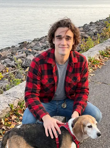 Josiah, AI character: the Duluth Lakewalk near the rocky shore of Lake Superior, crouched beside Mabel after an evening walk